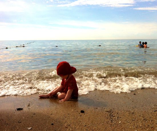Kleinkinder sollten am Strand immer eine Mütze tragen - auch wenn es schattig wirkt. Sonst droht ein Hitzeschlag.